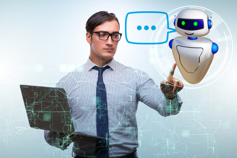 Concept of chat bot in modern business communication man with a laptop using conversational AI and interested in using all concepts of AI assistants