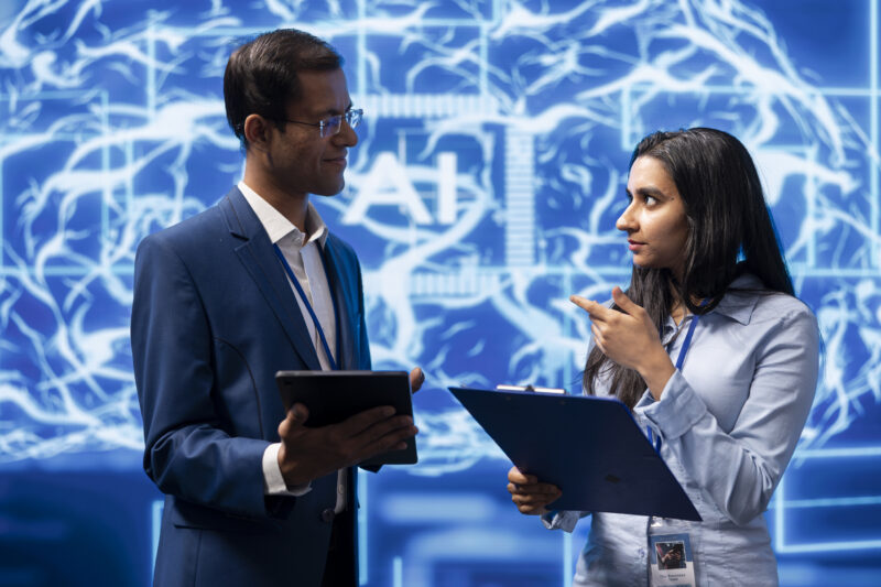 Computer scientists collaborating on developing AI system in modern lab tech team using cybersecurity in AI