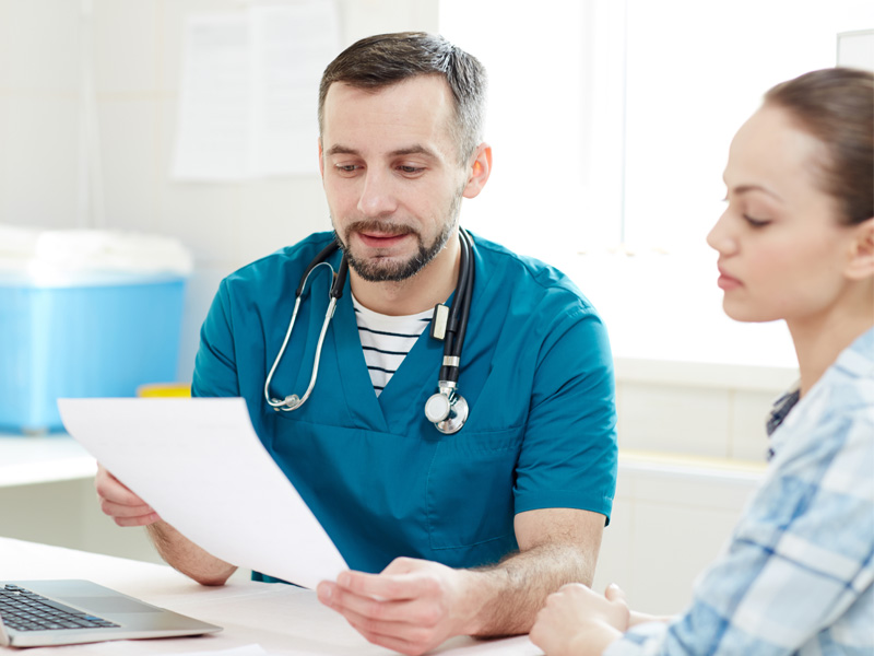 doctor consulting with patient to illustrate difference between pelvic exam and Pap smear
