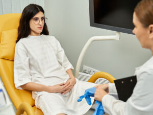 Doctor about to examine patient and talking about causes and stages of endometriosis
