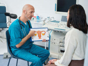 doctor with illustration of uterus to illustrate how PCOS affects fertility